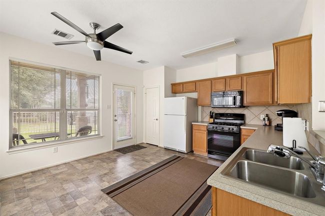 Bright kitchen with seamless access to the backyard, perfect for indoor-outdoor living. | Image 8