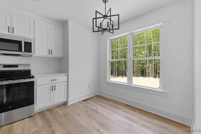 Kitchen with stainless steel appliances, baseboards, visible vents, and white cabinets | Image 14