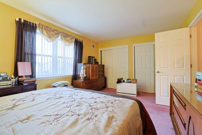 Bedroom featuring carpet floors, two closets, and visible vents | Image 16