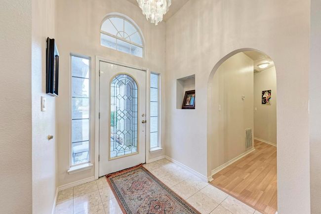 Tiled foyer featuring plenty of natural light, arched walkways, baseboards, and a high ceiling | Image 10