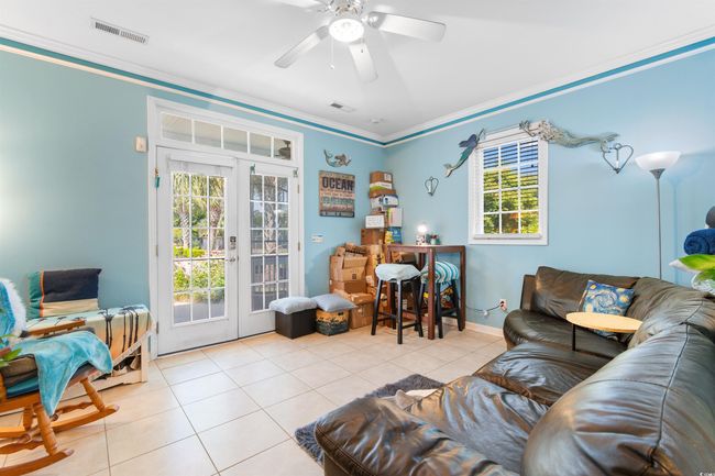 Tiled living area with french doors, ornamental molding, ceiling fan, and baseboards | Image 9
