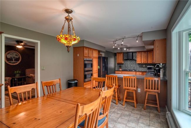 Dining room with ceiling fan and a baseboard radiator | Image 16