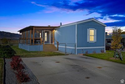 Manufactured / mobile home featuring a lawn and a sunroom | Image 1