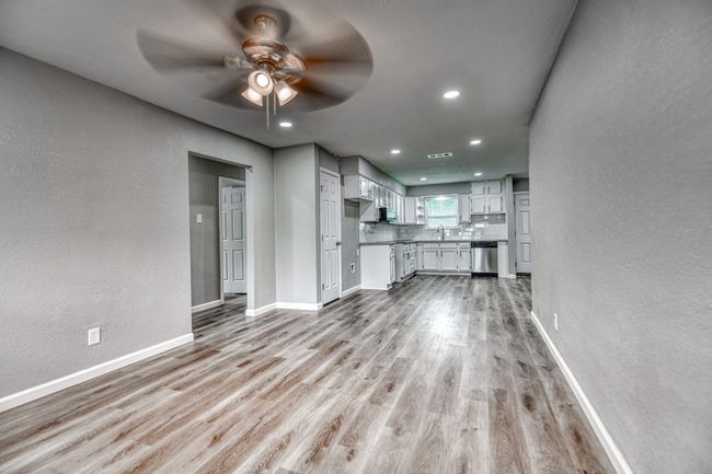 Unfurnished living room with a ceiling fan, a textured wall, light wood-style floors, and recessed lighting | Image 18