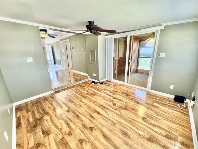 View of living room to rear screened in porch and back towards dinette/kitchen | Image 9
