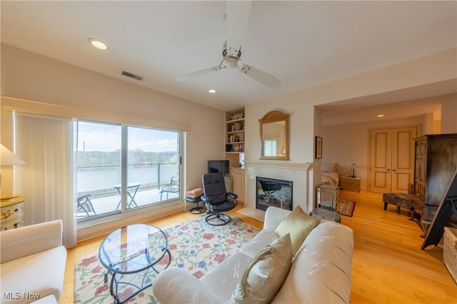 Sitting area in primary suite featuring recessed lighting, light wood-style floors, visible vents, a ceiling fan, and a fireplace with flush hearth | Image 35