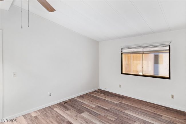 Primary bedroom with baseboards and wood style floors | Image 20