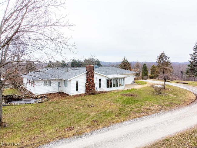 View of front of home with driveway, roof with shingles, a chimney, and a front yard | Image 5