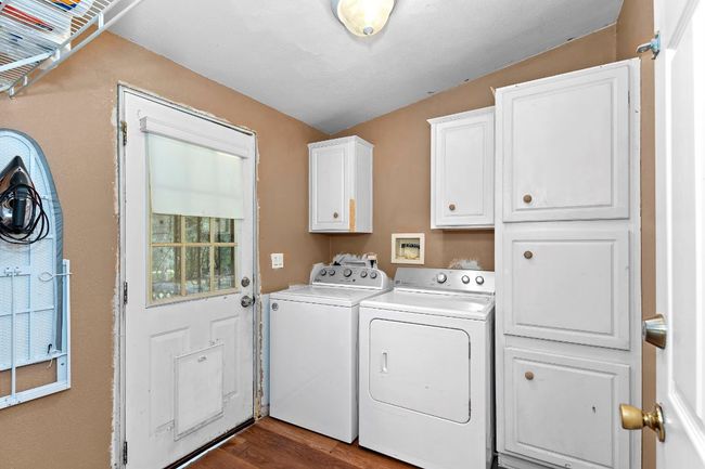 Laundry area with cabinet space, independent washer and dryer, and wood-style flooring | Image 18