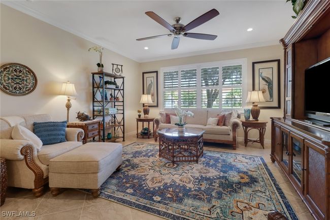 Living area with recessed lighting, ornamental molding, baseboards, light tile patterned flooring, and ceiling fan | Image 10