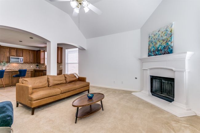 Large living room features a beautiful gas fireplace and arched walkways. | Image 9