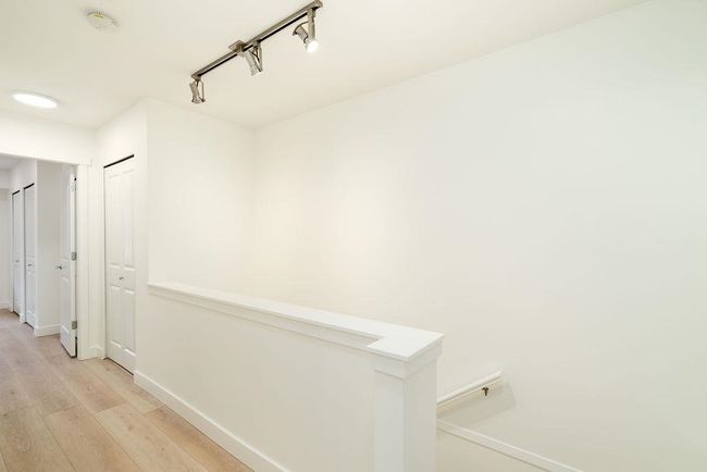 Corridor with baseboards, an upstairs landing, light wood-style floors, and track lighting | Image 24