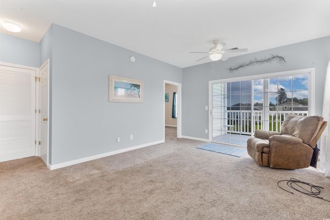 Living area featuring carpet flooring, a ceiling fan, and baseboards | Image 9