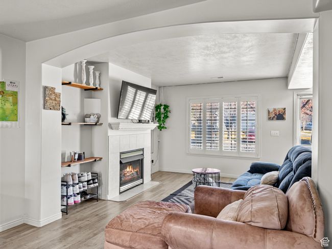 Living room with light hardwood / wood-style flooring and a tiled fireplace | Image 7