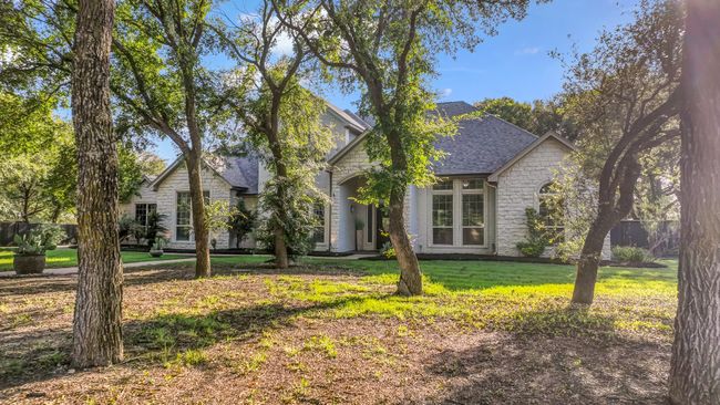 View of front facade featuring stone siding, a front lawn, and a shingled roof | Image 40