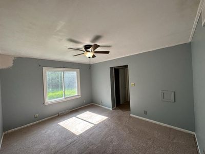 Carpeted empty room featuring ceiling fan and crown molding | Image 3