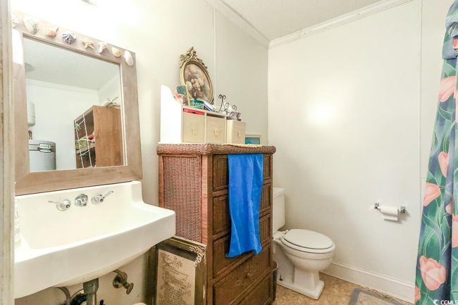 Full bathroom featuring crown molding, toilet, a sink, tile patterned flooring, and a shower with curtain | Image 15