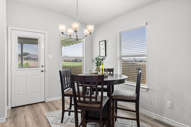Dining area with a chandelier, light wood-style flooring, vaulted ceiling, and plenty of natural light | Image 16