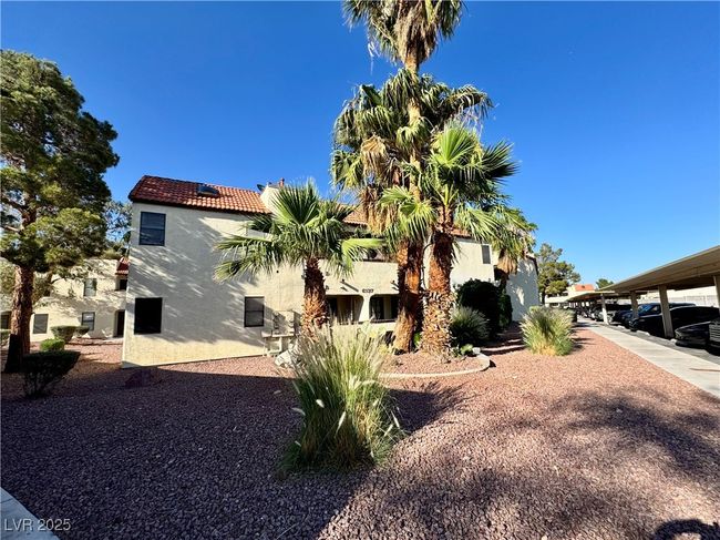 View of side of home featuring stucco siding and a tiled roof | Image 7
