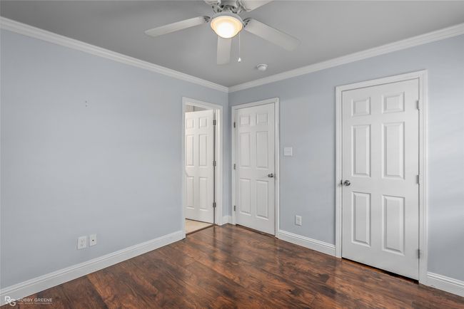 Unfurnished bedroom with crown molding, wood finished floors, and baseboards | Image 15