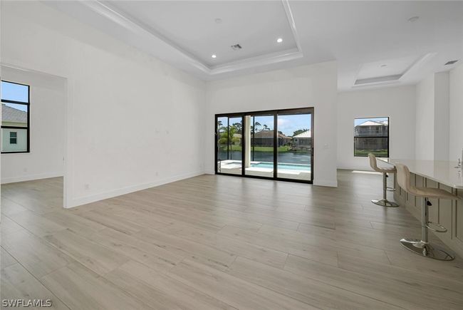 Open Great room with tray ceiling, accent lighting and adjoining Dinning room. | Image 4