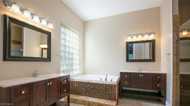 Bathroom with plenty of natural light, shower with separate bathtub, tile patterned flooring, and vanity | Image 12