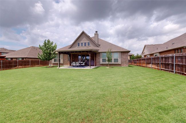 Rear view of house featuring brick siding, a chimney, and a patio area | Image 37