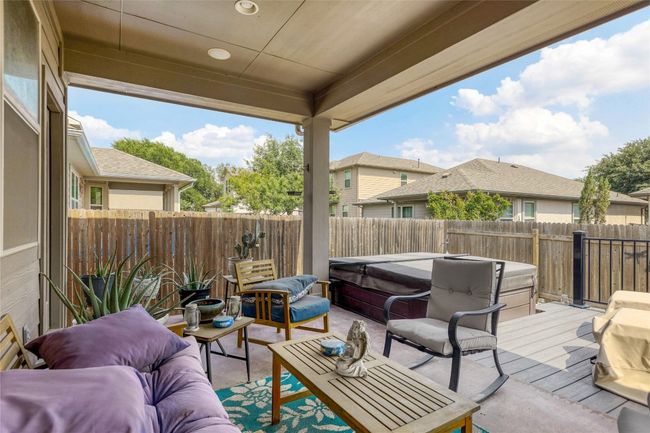 Fenced backyard featuring a hot tub, an outdoor hangout area, a patio area, and a wooden deck | Image 26