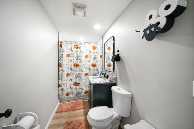 Full bath featuring baseboards, toilet, recessed lighting, wood finished floors, and vanity | Image 13