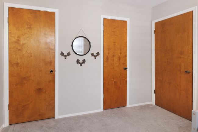 Unfurnished bedroom with light carpet and baseboards | Image 26