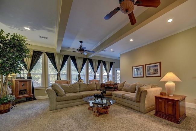 The expansive den has a double sided fireplace and a full wall of windows with a great view of the property. | Image 16