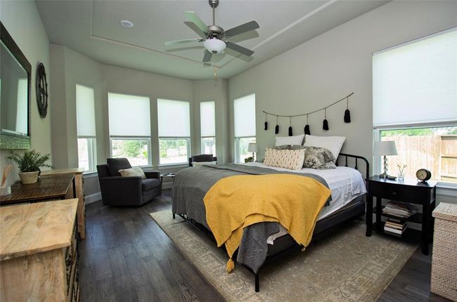 The primary bedroom features a bay window and a ceiling fan. | Image 14