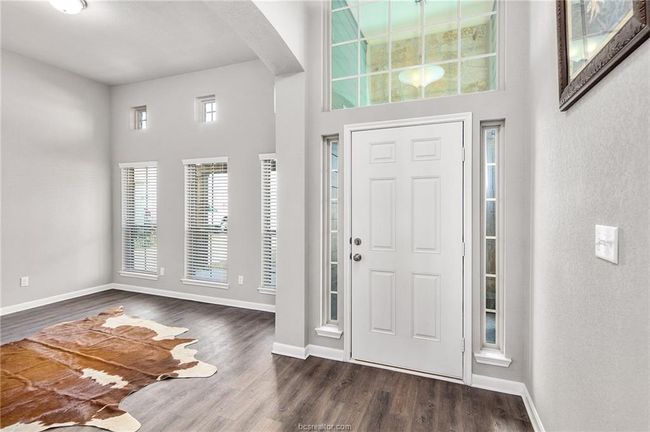 Entryway featuring a towering ceiling and dark hardwood / wood-style flooring | Image 5