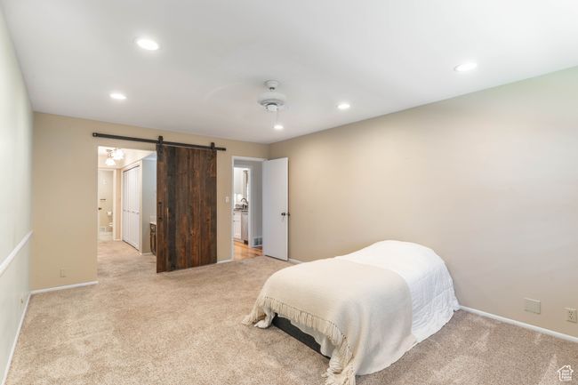 Bedroom featuring a barn door, light colored carpet, and recessed lighting | Image 20