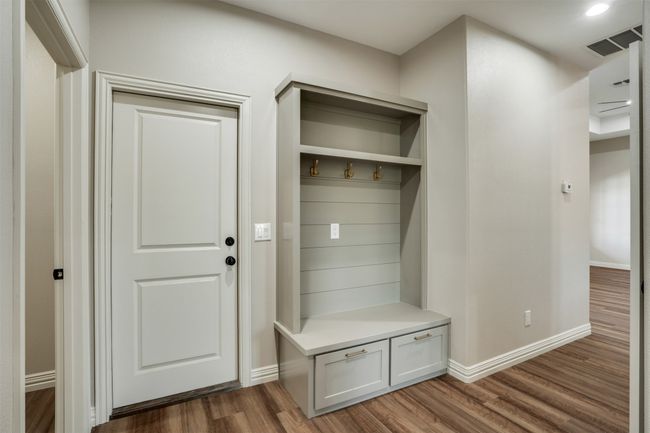 Mudroom with baseboards, wood finished floors, and visible vents | Image 24