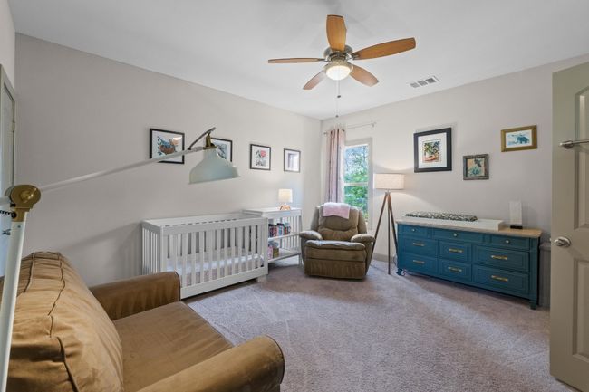 Carpeted bedroom with visible vents, a ceiling fan, and a crib | Image 22