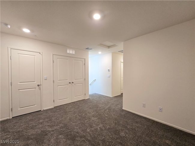 Empty room with dark colored carpet, a smoke detector, baseboards, recessed lighting, and attic access | Image 16