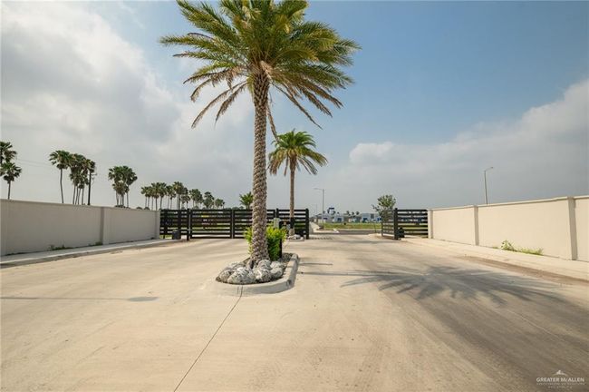 View of concrete road with curbs and a gated entry | Image 24