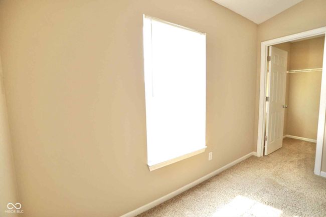 unfurnished bedroom with baseboards, a spacious closet, a closet, and carpet flooring | Image 31