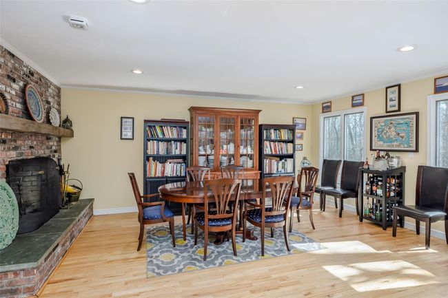 Dining space featuring baseboards, recessed lighting, crown molding, a brick fireplace, and light wood-type flooring | Image 17