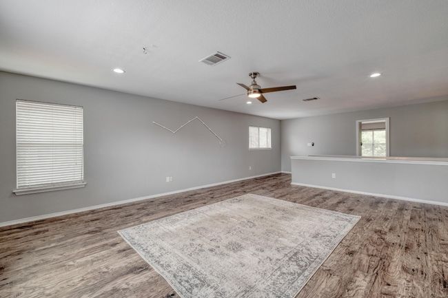 Empty room featuring wood finished floors, a ceiling fan, healthy amount of natural light, and recessed lighting | Image 18