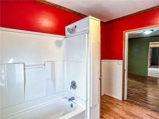 Bathroom with shower / bath combination, ornamental molding, and wood finished floors | Image 14