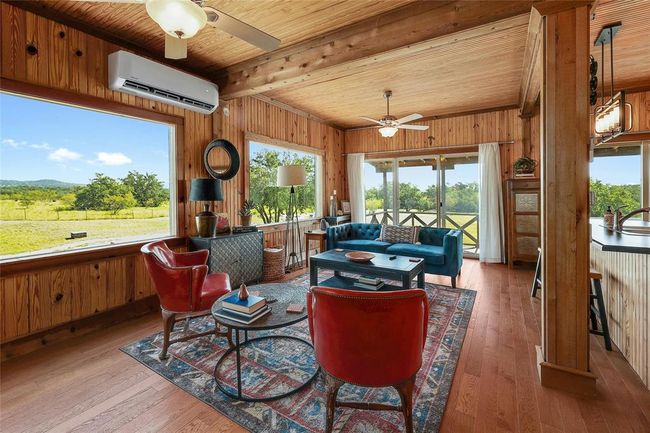 Sunroom / solarium featuring beamed ceiling, plenty of natural light, and a wall mounted air conditioner | Image 8