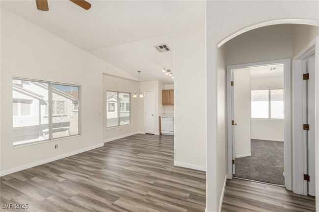 Unfurnished living room with vaulted ceiling, a ceiling fan, arched walkways | Image 9