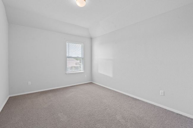 Carpeted empty room featuring baseboards and lofted ceiling | Image 24