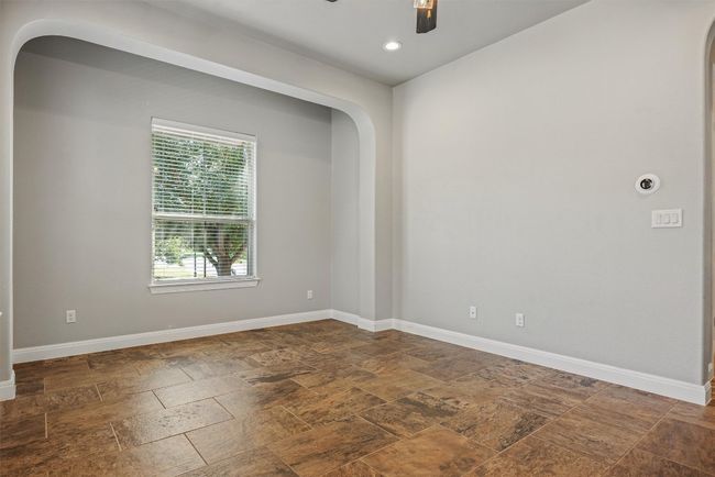 Main room of the casita could be a living/bedroom or office with dark stone finish flooring, recessed lighting, and ceiling fan | Image 14
