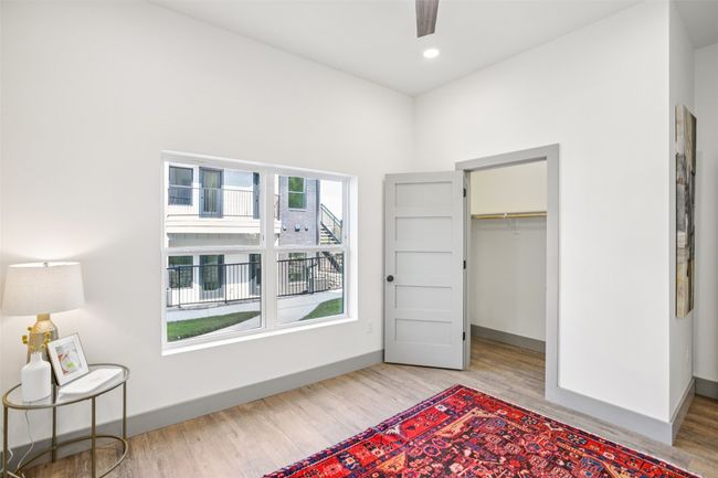 Bedroom featuring wood finished floors, ceiling fan, recessed lighting, and a walk in closet | Image 22