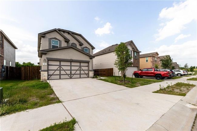 View of front facade with stucco siding, driveway, and an attached garage | Image 31