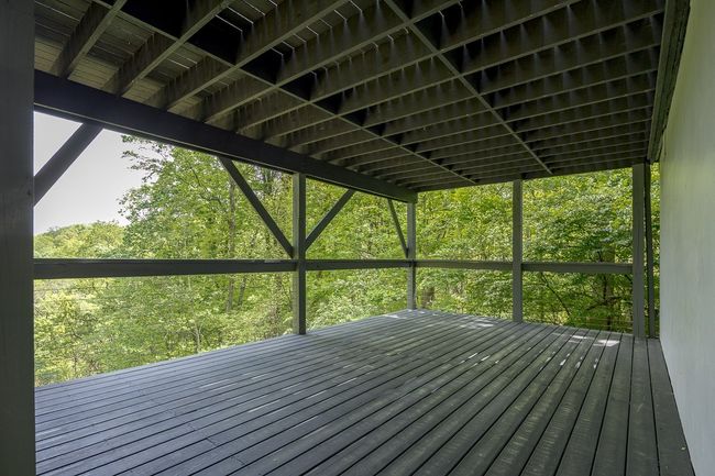 Imagine stepping onto a beautiful covered balcony, nestled among the trees and surrounded by the calming presence of nature. | Image 11