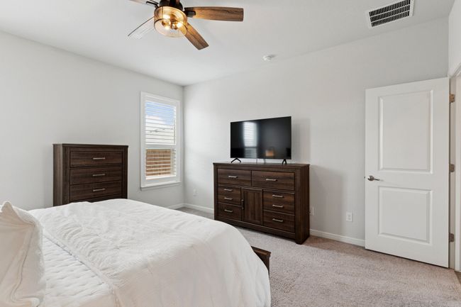 Bedroom featuring light colored carpet and ceiling fan | Image 15